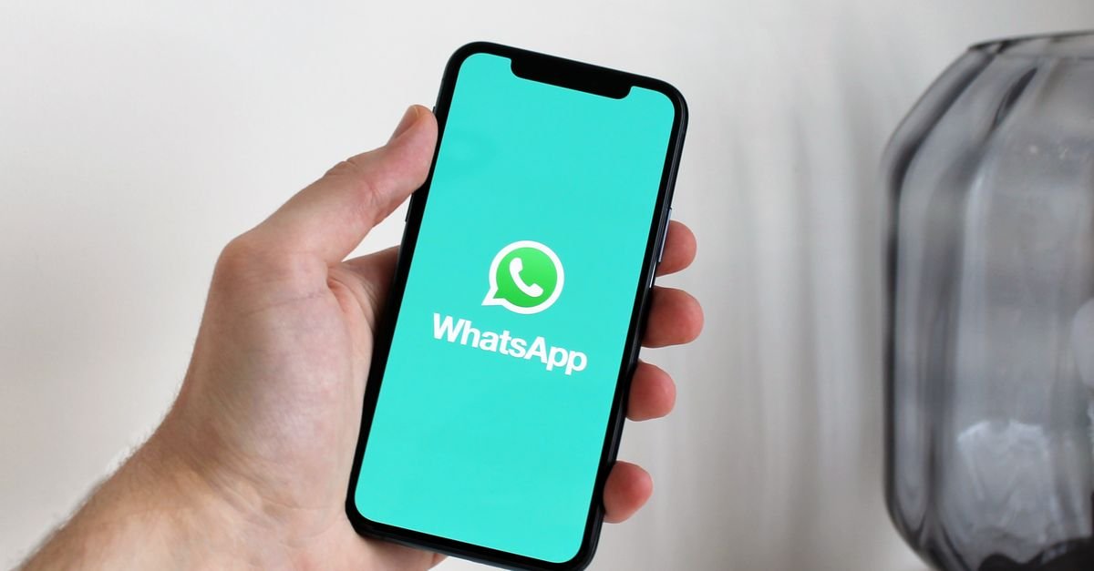 Mão segurando celular com a tela do WhatsApp aberta, aplicativo usado no golpe do falso advogado