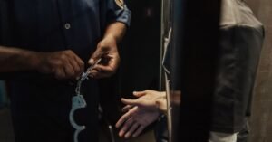 Policial algemando um homem durante prisão