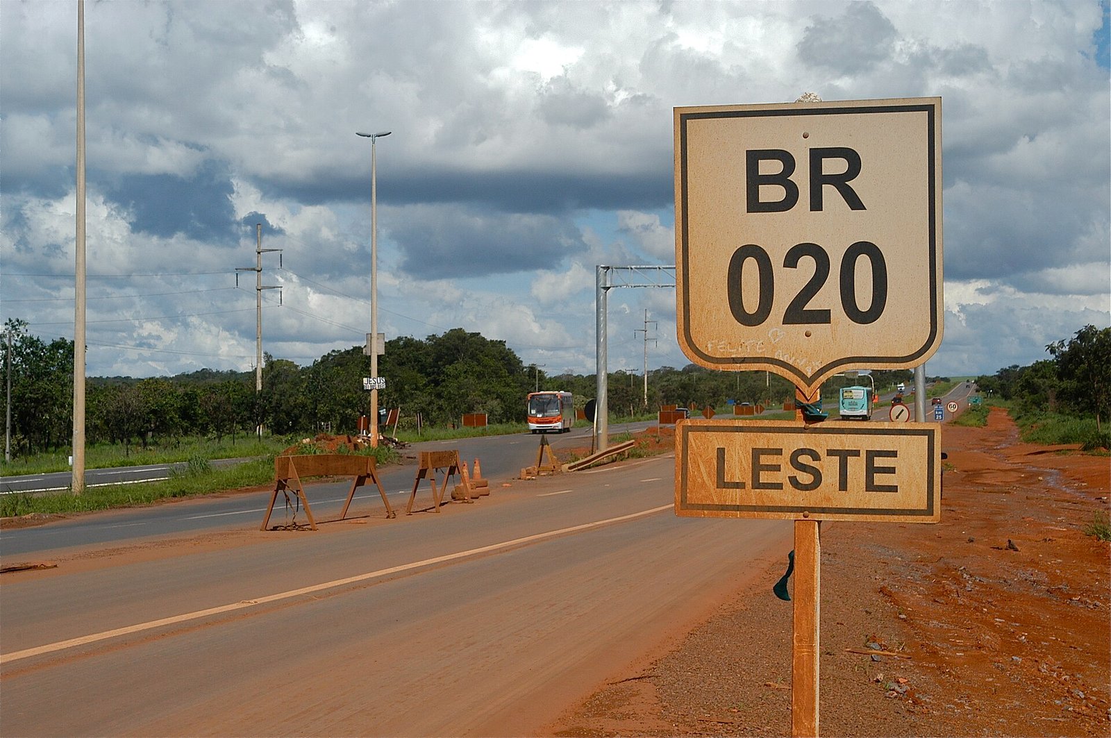 Trecho da BR-020 em Planaltina, com solo vermelho e vegetação de cerrado às margens da pista
