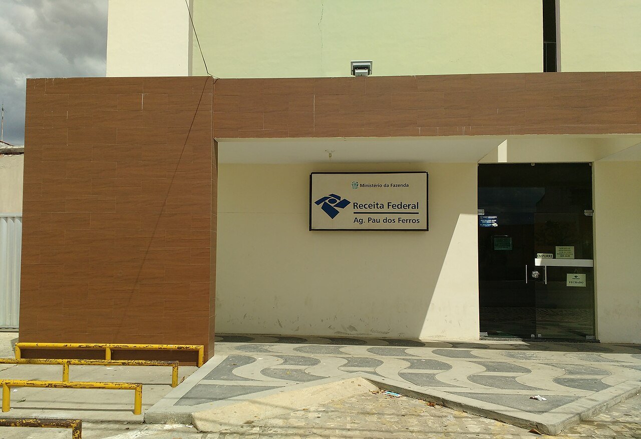 Fachada de agencia da Receita Federal com placa do Ministerio da Fazenda e do orgao na entrada
