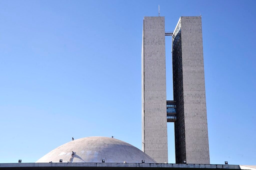 Torres e cúpula do Congresso Nacional, em Brasília, vistas de baixo com céu azul