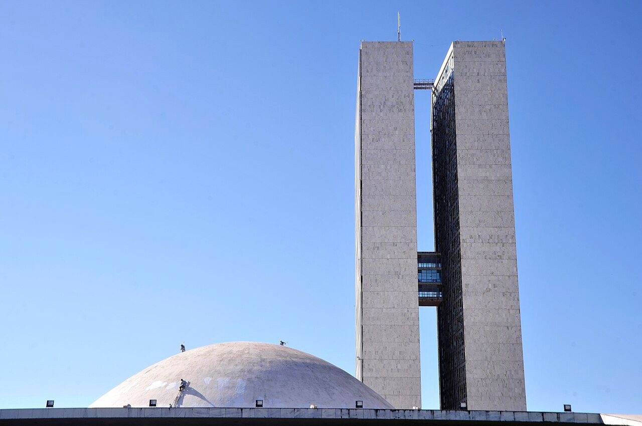 Torres e cúpula do Congresso Nacional, em Brasília, vistas de baixo com céu azul