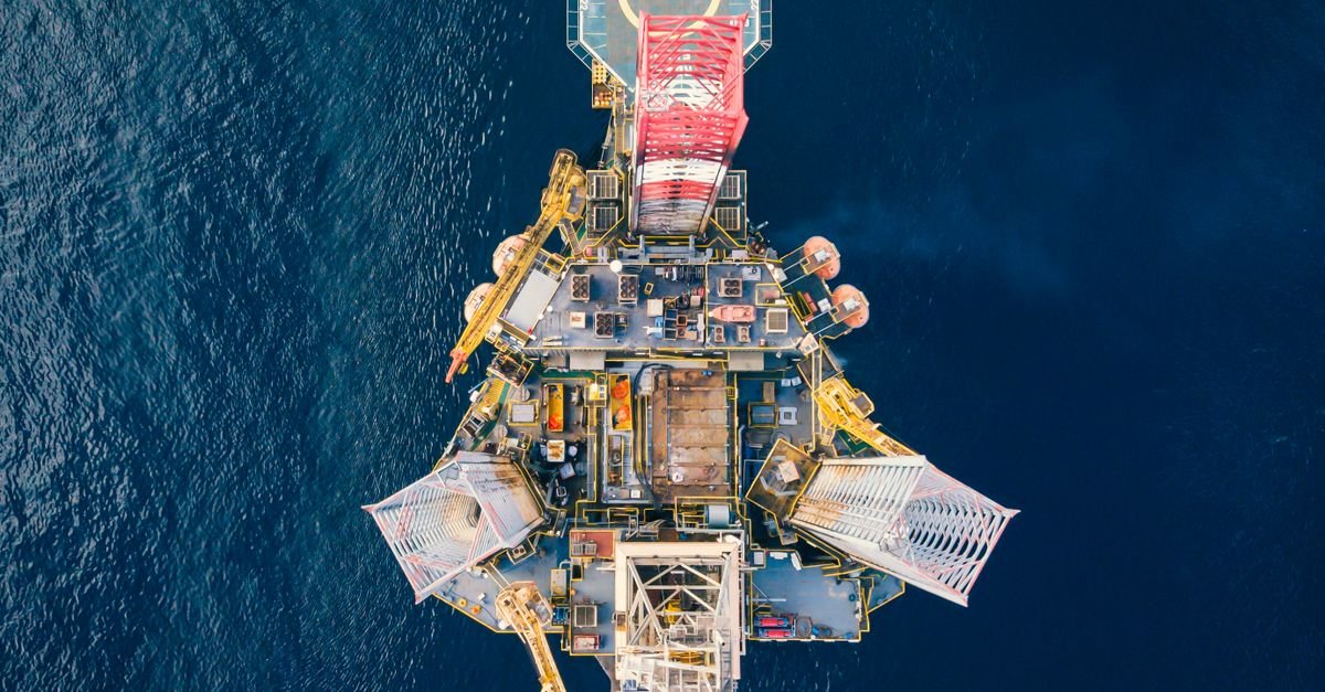 Vista aérea de plataforma de petróleo e gás cercada por mar azul profundo