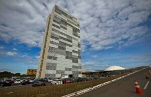 Edificio anexo da Camara dos Deputados e cupula do Congresso Nacional em Brasilia sob ceu com nuvens