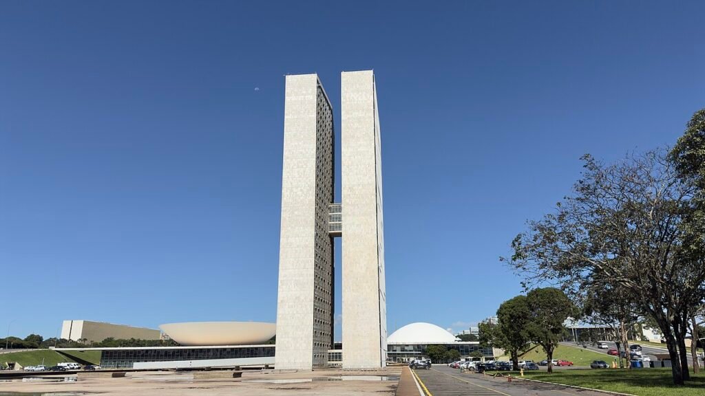 Fachada do Congresso Nacional em Brasília, com as duas torres e as cúpulas da Câmara e do Senado sob céu azul