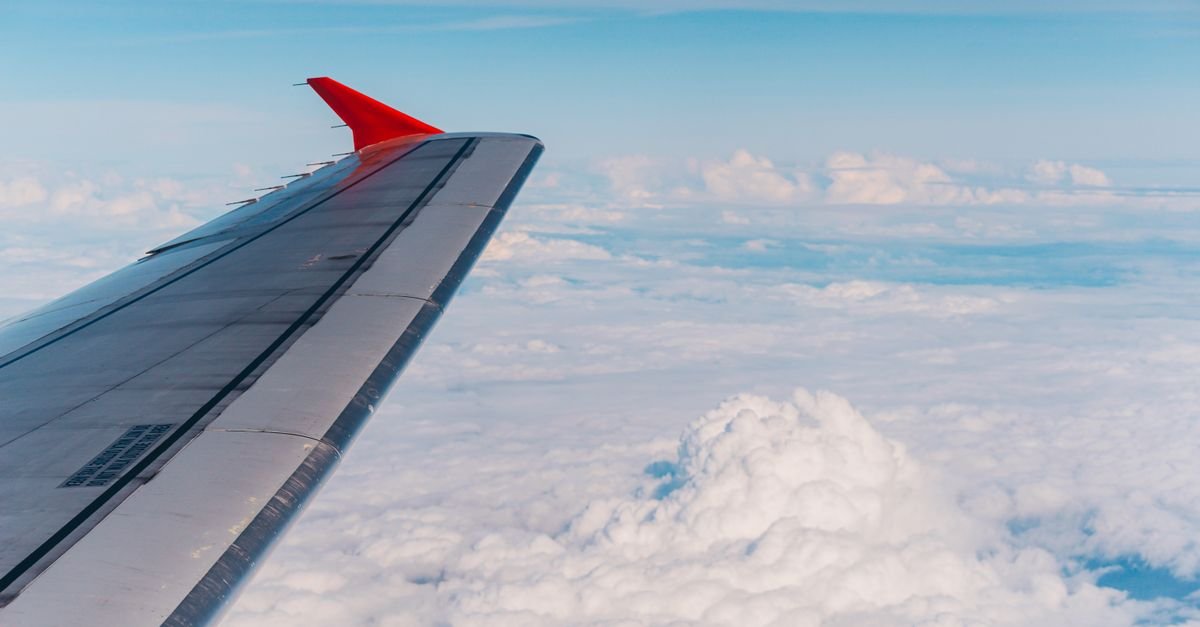 Asa de aviao sobre nuvens vista da janela durante voo