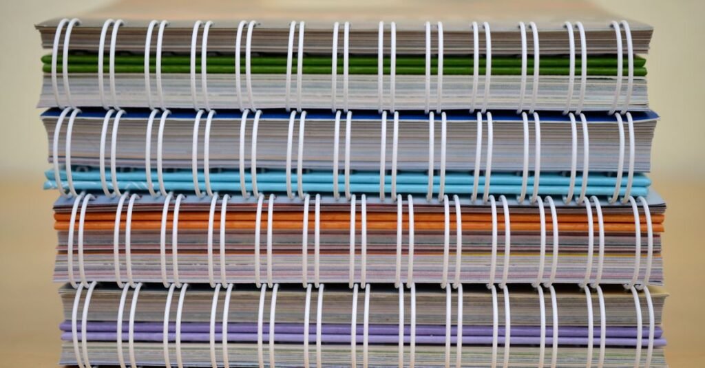Pilha de cadernos coloridos sobre mesa, ilustrando o financiamento estudantil