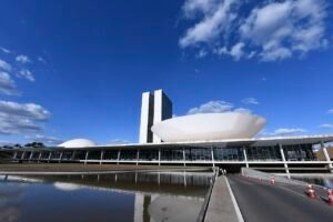 Fachada do Congresso Nacional em Brasília vista do espelho d'água em dia de céu azul