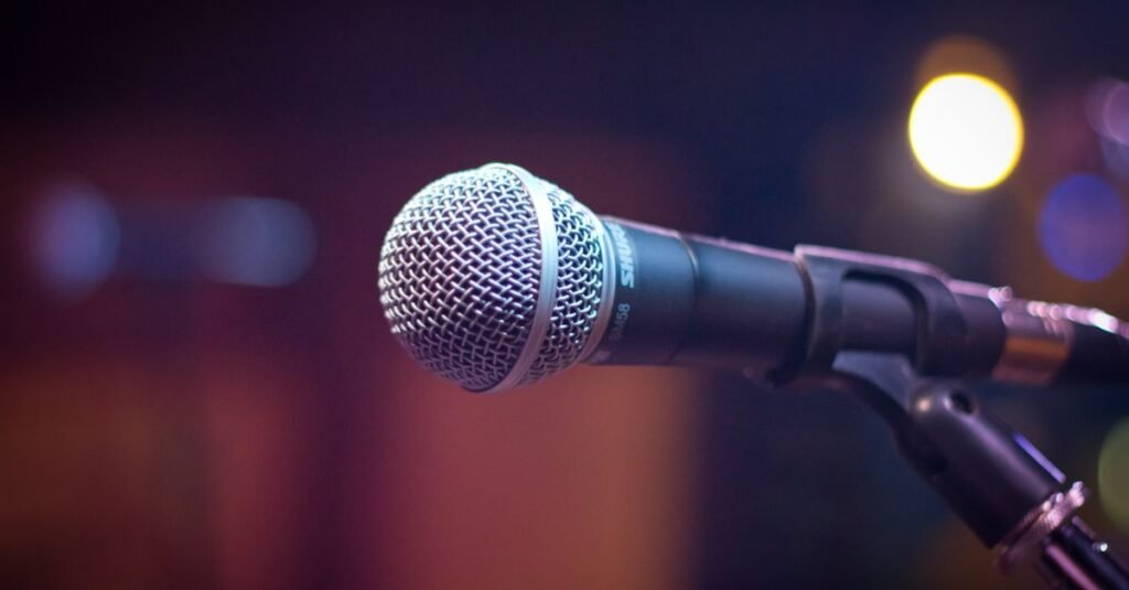 Microfone em pedestal diante de luzes de palco, em referência a convenção partidária