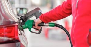 Pessoa abastece um carro com bico de combustível verde em posto