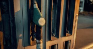 Bico de bomba de combustível encaixado na bomba de um posto, em close