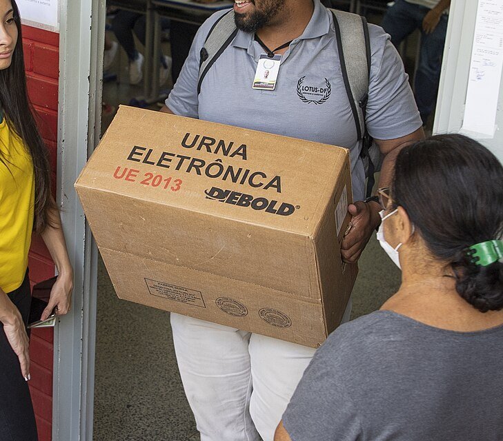 Caixa de transporte de urna eletrônica sendo levada a uma seção eleitoral