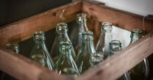 Engradado de madeira com garrafas de vidro vazias e sem rótulo