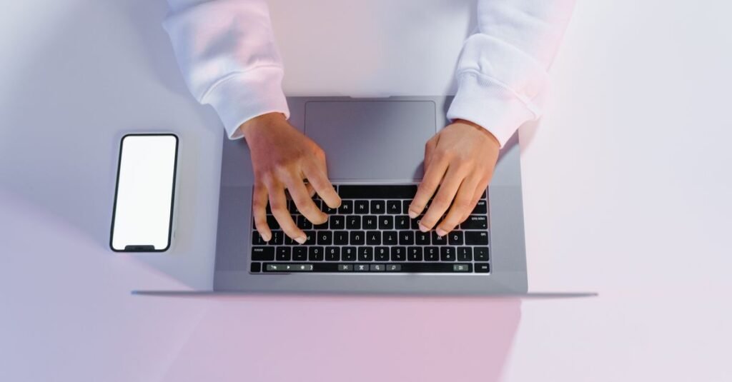 Mãos digitando em notebook, representando o acesso digital aos serviços da Receita Federal
