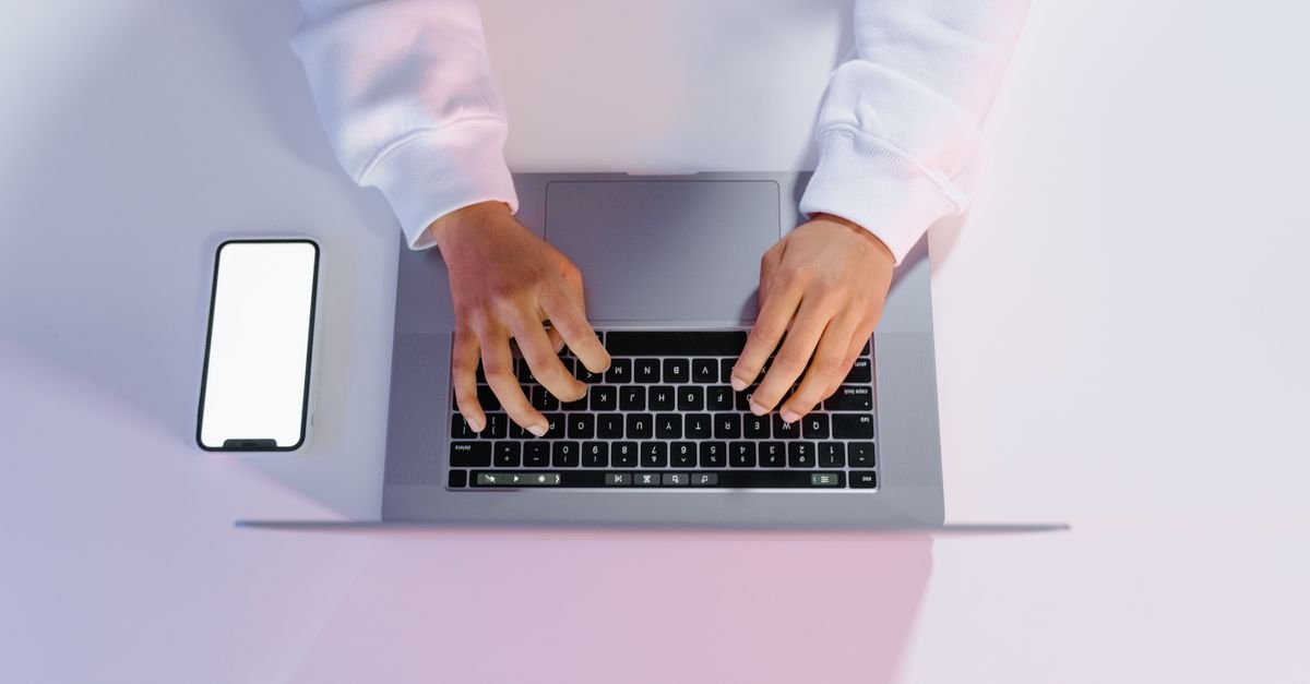Mãos digitando em notebook, representando o acesso digital aos serviços da Receita Federal