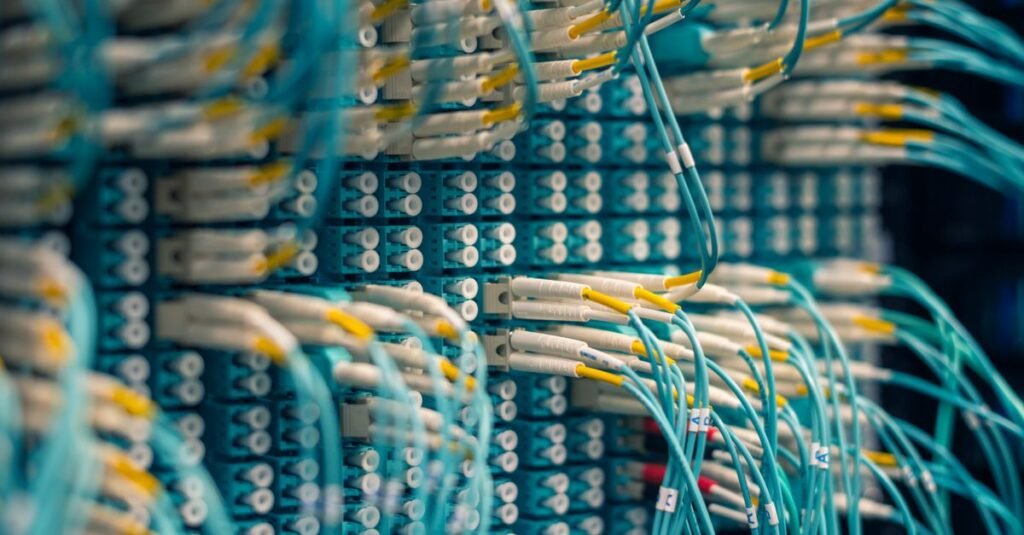 Painel de conexões de fibra óptica com cabos azuis em data center