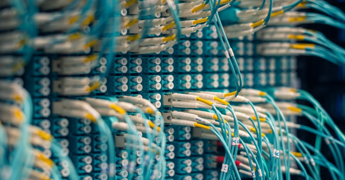 Painel de conexões de fibra óptica com cabos azuis em data center