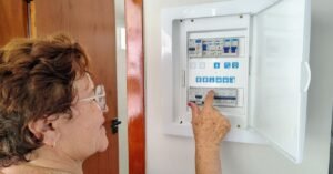 Mulher aciona disjuntor em quadro de energia residencial