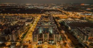 Vista aérea noturna de quadras residenciais e vias iluminadas de Brasília