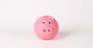 Cofrinho rosa em forma de porquinho sobre fundo branco