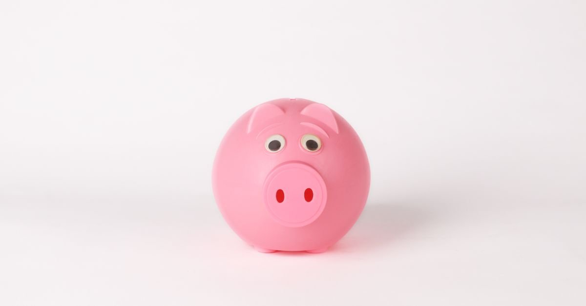 Cofrinho rosa em forma de porquinho sobre fundo branco