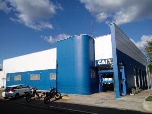 Fachada de agência da Caixa Econômica Federal, com letreiro azul e laranja
