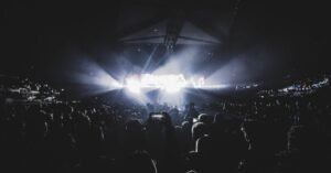 Público em show noturno com luzes de palco em arena