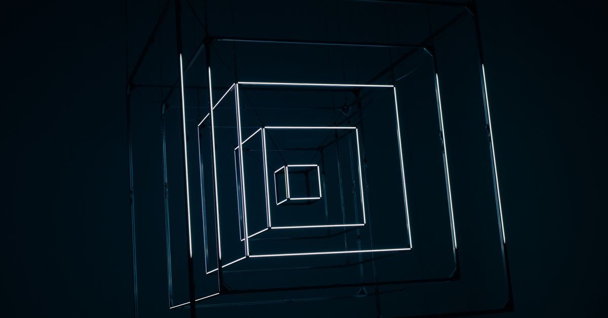 Instalação de arte com estruturas geométricas de luz branca suspensas em ambiente escuro