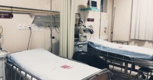 Sala de emergencia hospitalar vazia com dois leitos e equipamentos