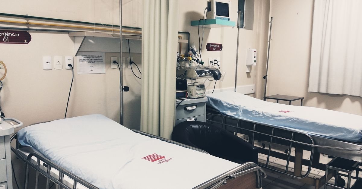 Sala de emergencia hospitalar vazia com dois leitos e equipamentos