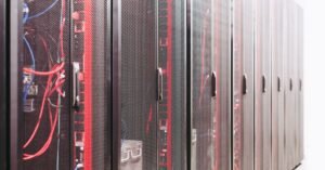 Fileira de racks de servidores com cabos de rede em sala de data center