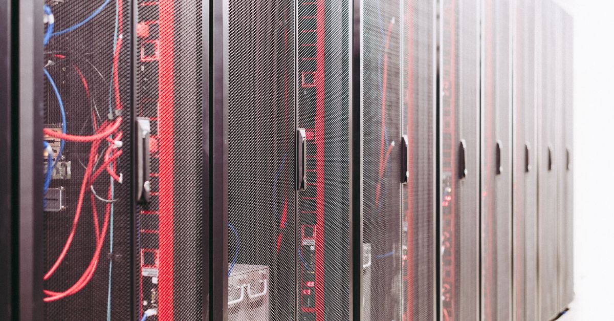 Fileira de racks de servidores com cabos de rede em sala de data center