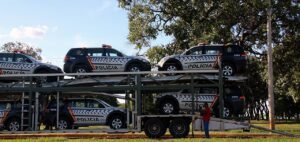 Viaturas da Polícia Militar do Distrito Federal sobre caminhão-cegonha, com a inscrição POLÍCIA na lataria