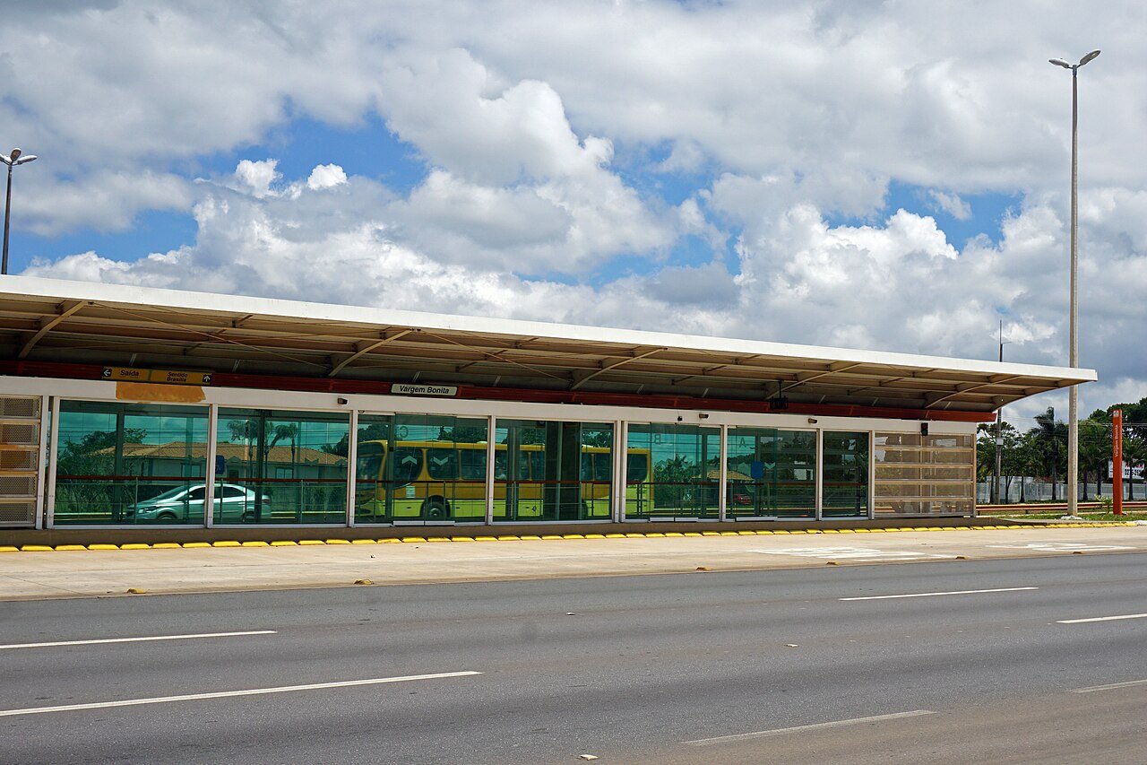 Estação do BRT no Distrito Federal, com ônibus amarelo do sistema ao fundo e o corredor exclusivo em primeiro plano