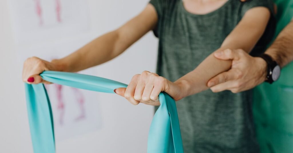 Sessão de fisioterapia com faixa elástica de resistência para reabilitação de braço