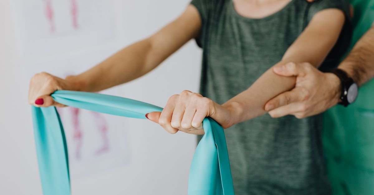 Sessão de fisioterapia com faixa elástica de resistência para reabilitação de braço