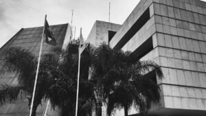 Fachada da sede do Tribunal Regional Eleitoral do Distrito Federal, em Brasília, com bandeiras e palmeiras