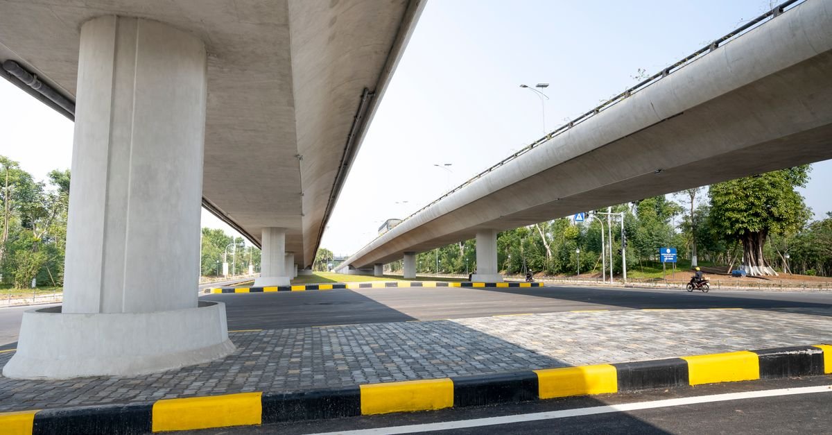 Vista de baixo de viadutos de concreto sobre avenida asfaltada