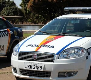 Frente de uma viatura branca da Polícia Militar do Distrito Federal com faixas coloridas e sinalizador no teto