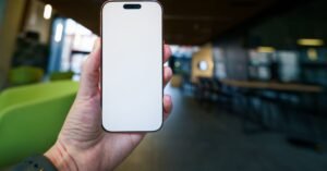 Mão segurando um celular com a tela em branco