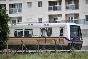 Trem do Metrô-DF parado ao lado de prédio residencial