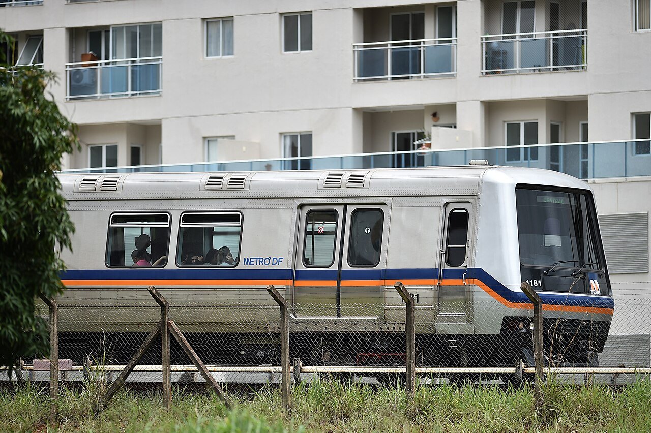 Trem do Metrô-DF parado ao lado de prédio residencial