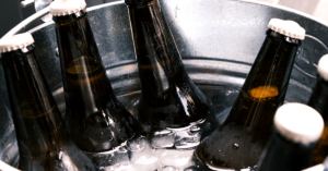 Garrafas de cerveja geladas dentro de balde de metal com gelo