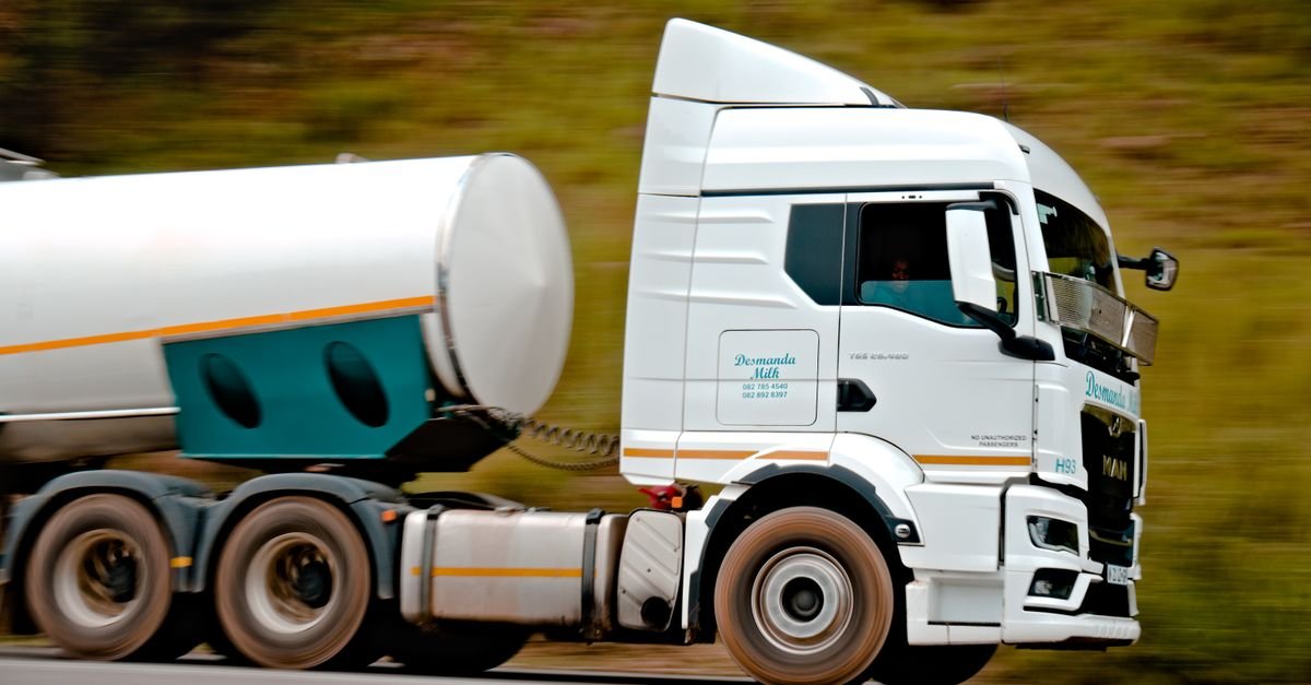 Caminhão-tanque branco em movimento em rodovia