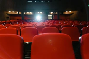 Sala de cinema com poltronas vermelhas vazias