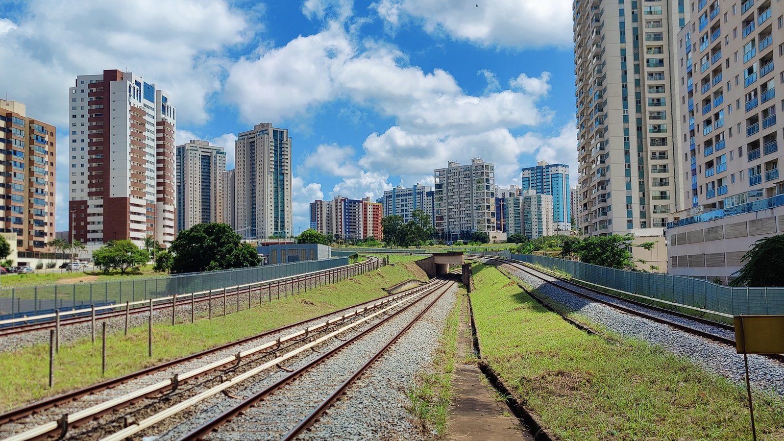 Prédios residenciais de Águas Claras vistos da estação de metrô, com a linha férrea em primeiro plano