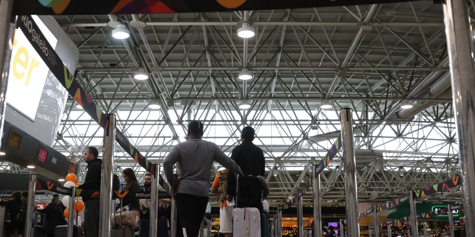 Fila de passageiros com malas no saguão de embarque do aeroporto RIOgaleão