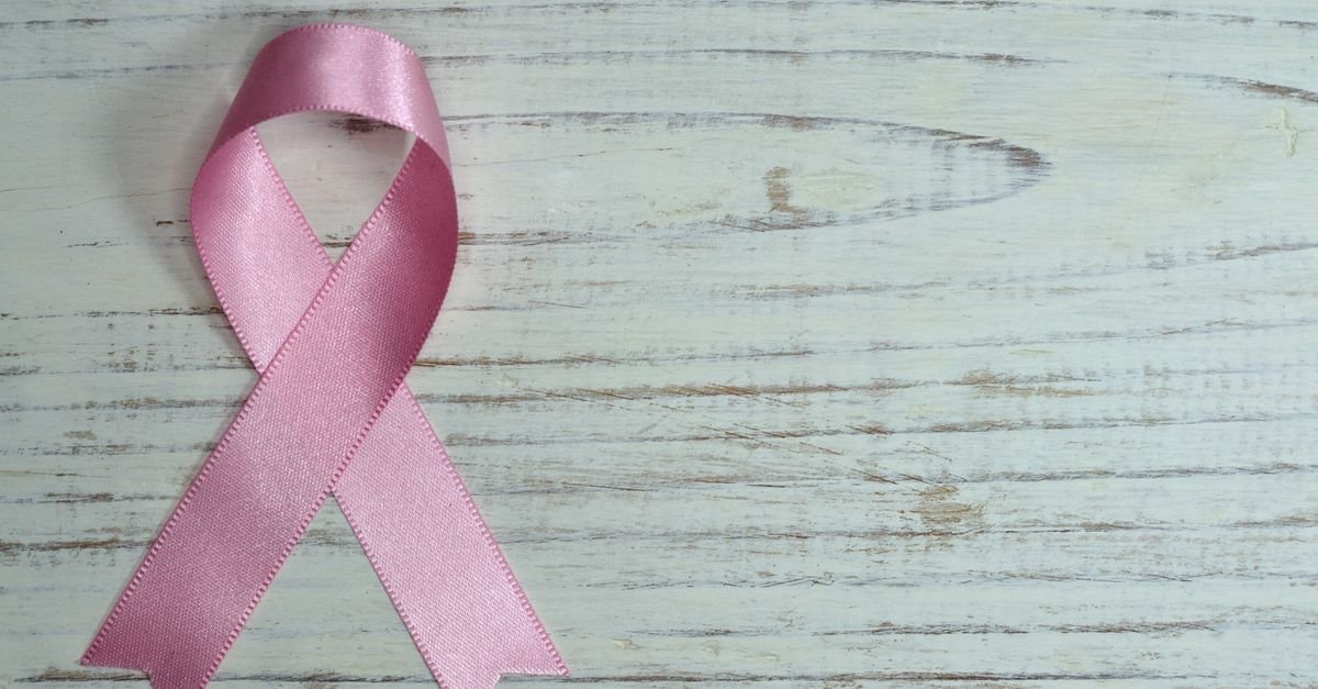 Laço rosa, símbolo da luta contra o câncer de mama, sobre fundo de madeira clara