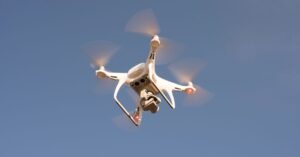 Drone branco em voo contra o céu azul