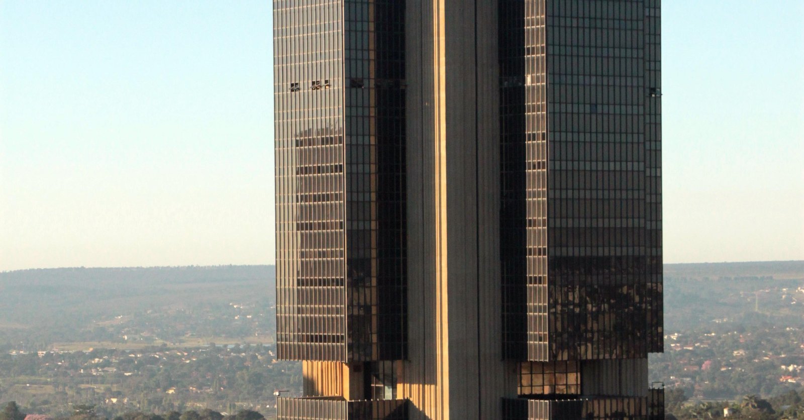 Torre do edifício-sede do Banco Central do Brasil, em Brasília, vista de frente com a cidade ao fundo